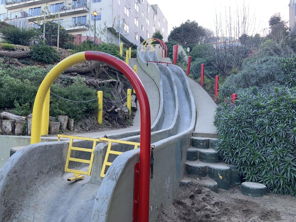 Concrete slides at Seward Mini Park with people sliding down on cardboard