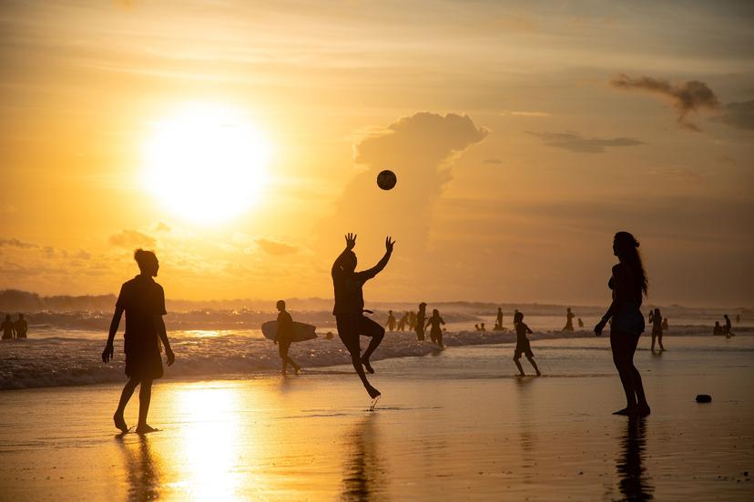 Group of friends at Ocean Beach bonfire pit at sunset